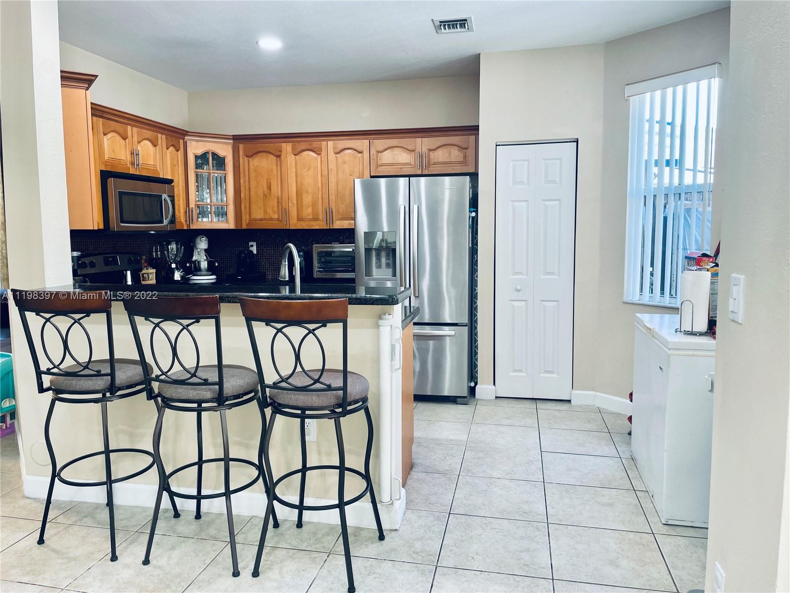 10975 Southwest 246th Street Homestead, FL 33032 - Photo 5 of 20 a view of a chairs in kitchen and a window