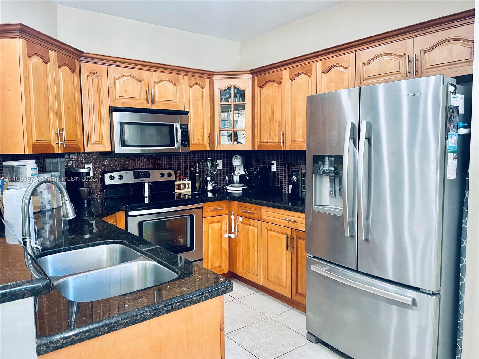 10975 Southwest 246th Street Homestead, FL 33032 - Photo 6 of 20 a kitchen with stainless steel appliances granite countertop a refrigerator and a sink