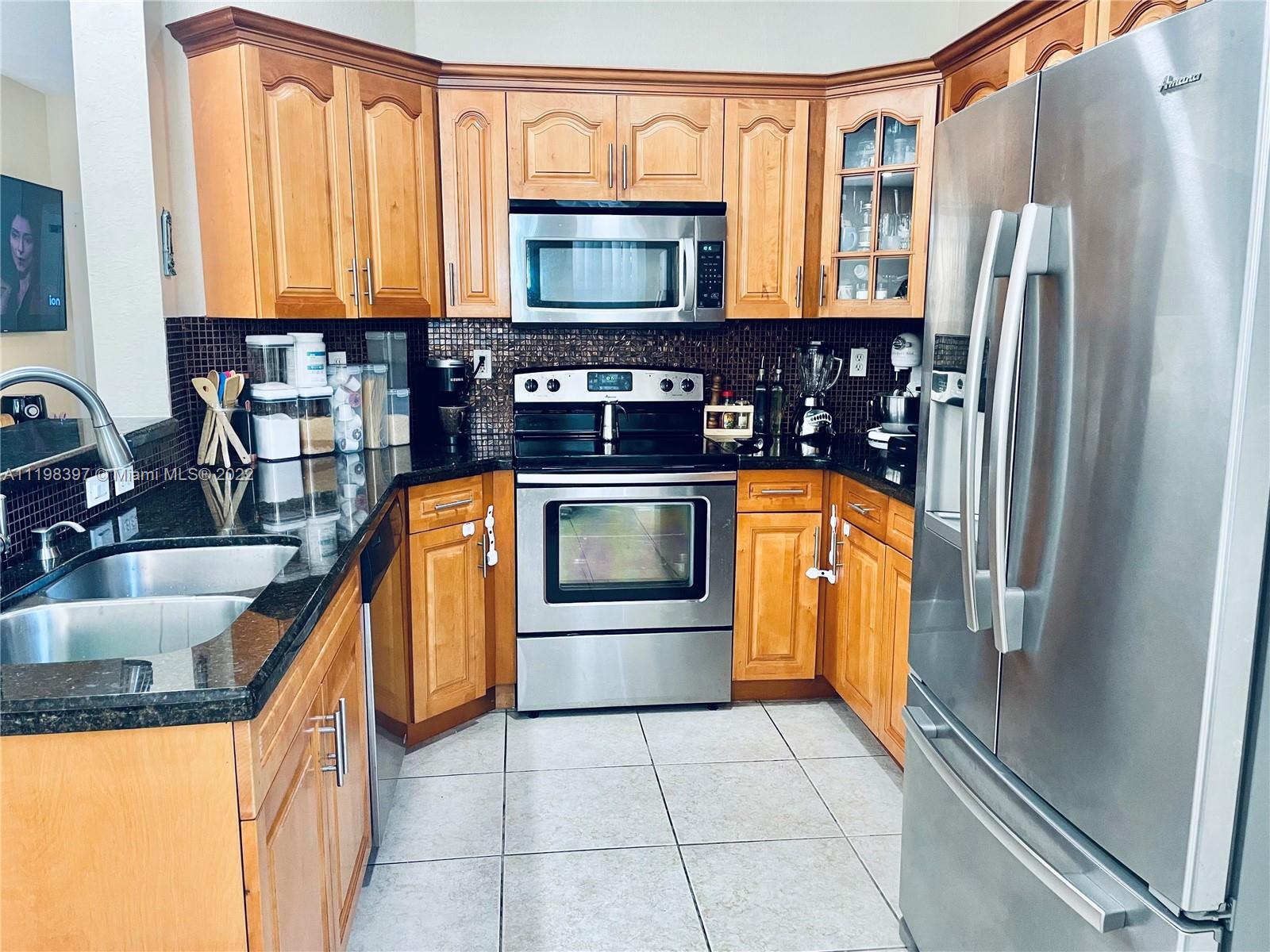10975 Southwest 246th Street Homestead, FL 33032 - Photo 7 of 20 a kitchen with stainless steel appliances granite countertop a sink a stove and a refrigerator