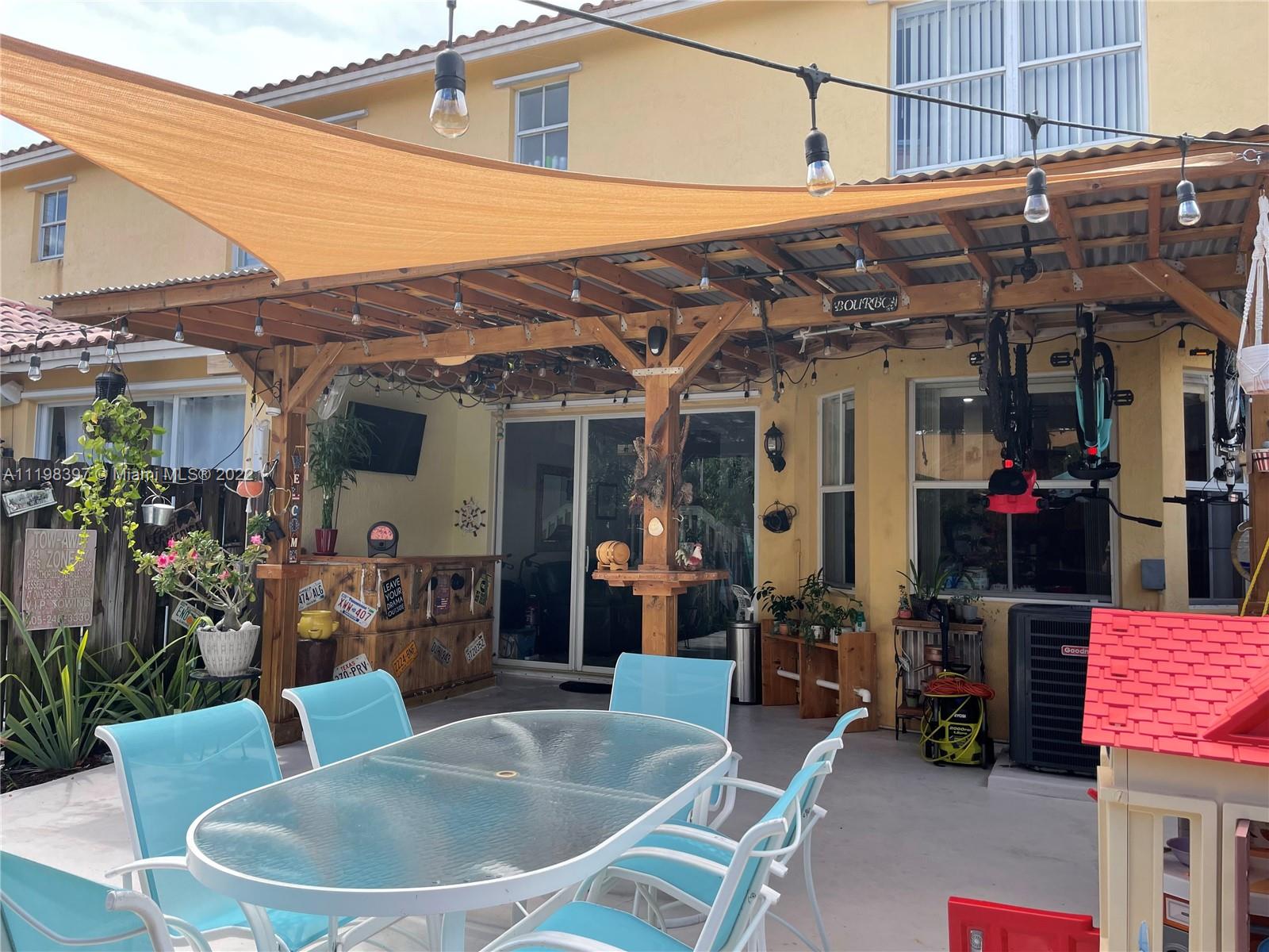 10975 Southwest 246th Street Homestead, FL 33032 - Photo 9 of 20 a view of a patio with table and chairs potted plants