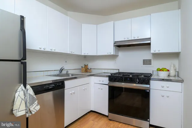 a kitchen with white cabinets and appliances