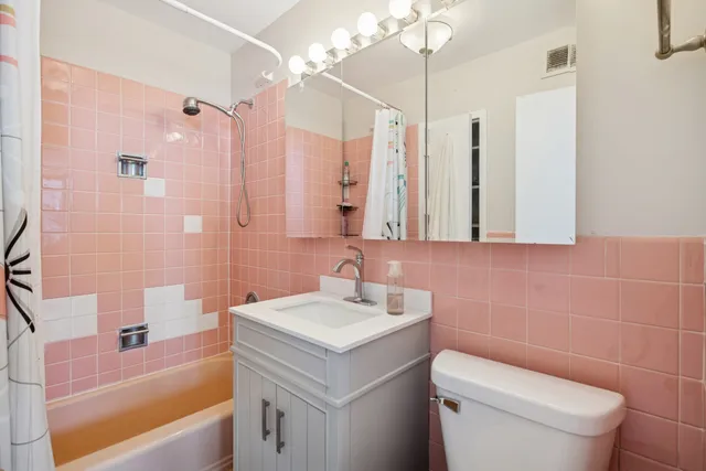 a bathroom with a sink a toilet a tub and shower