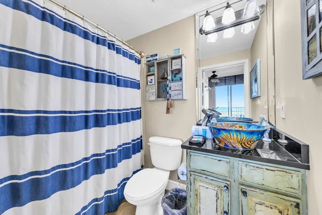 a bathroom with a sink a toilet and shower curtain