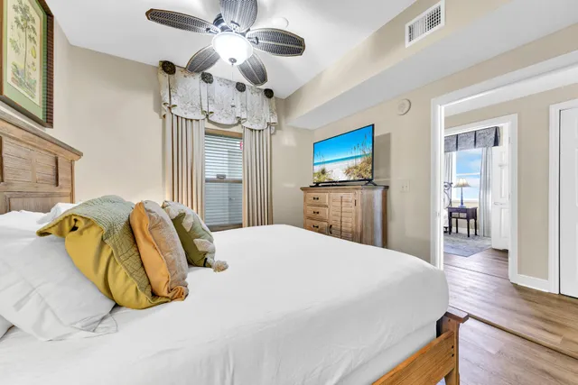a bedroom with a bed dresser and wooden floor