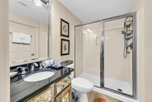 a bathroom with a granite countertop sink toilet mirror and shower