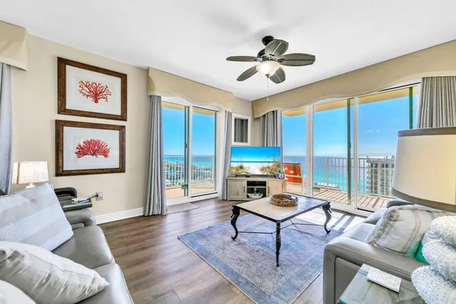 a living room with furniture kitchen view and a large window