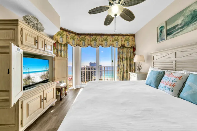 a spacious bedroom with a large bed and a flat tv screen on dresser