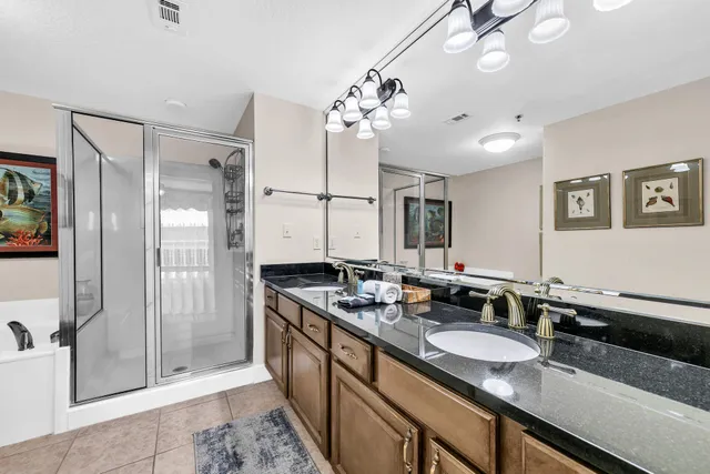 a bathroom with a granite countertop sink a large mirror and a shower