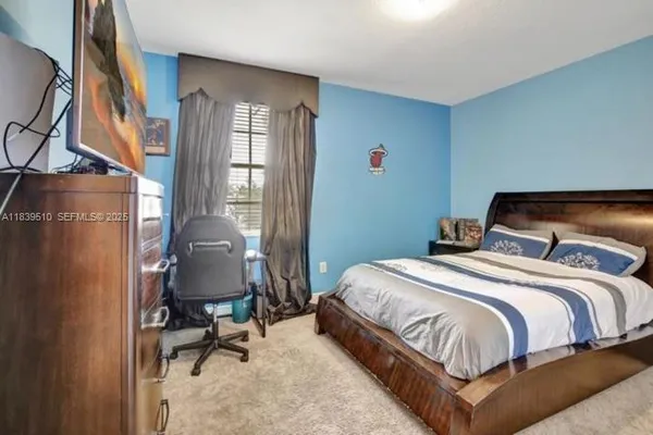 a bedroom with a bed and a flat tv screen