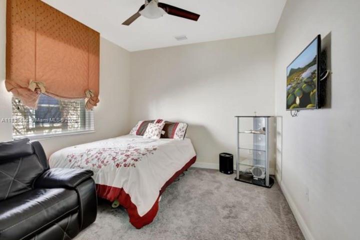 5078 Southwest 183rd Avenue Miramar, FL 33029 - Photo 12 of 15 a bedroom with a bed and a flat tv screen