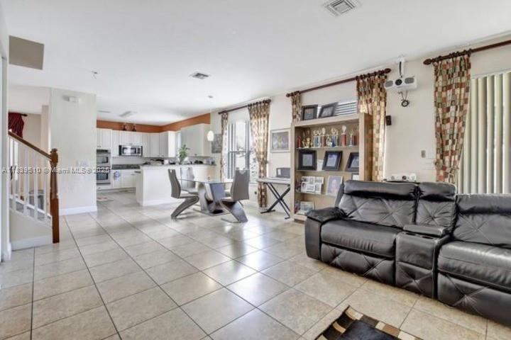 5078 Southwest 183rd Avenue Miramar, FL 33029 - Photo 4 of 15 a living room with furniture and a book shelf