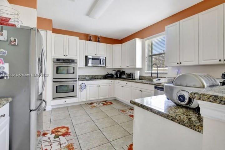 5078 Southwest 183rd Avenue Miramar, FL 33029 - Photo 5 of 15 a kitchen with stainless steel appliances granite countertop a sink stove refrigerator and cabinets