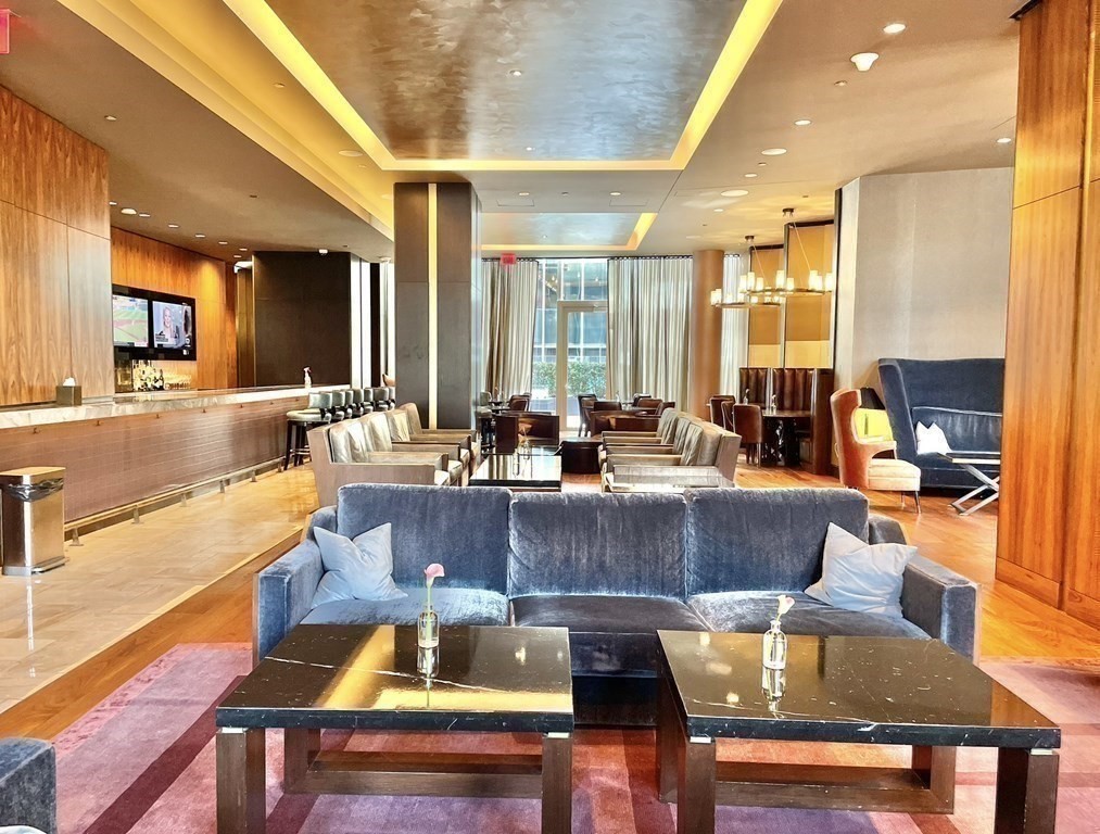 1 Franklin Street, Unit 4204 Boston, MA 02110 - Photo 19 of 37 a view of a dining room with furniture a chandelier and wooden floor