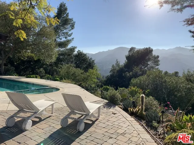 an empty room with wooden floor fireplace and windows