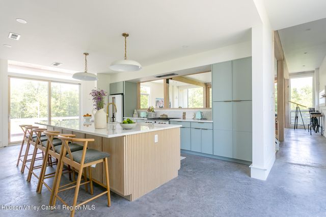 a kitchen with kitchen island granite countertop lots of white cabinets a dining table and chairs