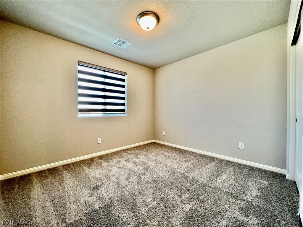 7845 Morganite Avenue Las Vegas, NV 89113 - Photo 18 of 21 A well-lit room offers ample space, complete with soft carpeting and a window for natural light.