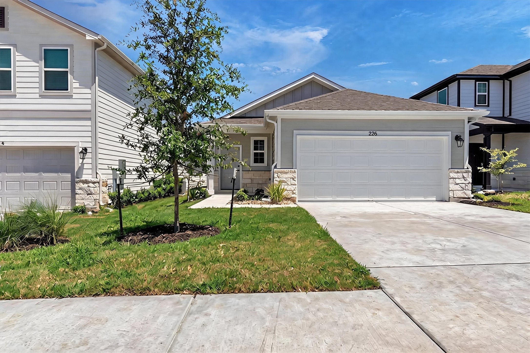 228 Bendecido Loop Elgin, TX 78621 - Photo 2 of 16 A well-maintained lawn and concrete driveway welcome you to this inviting property, featuring a single-car garage and modern exterior finishes.
