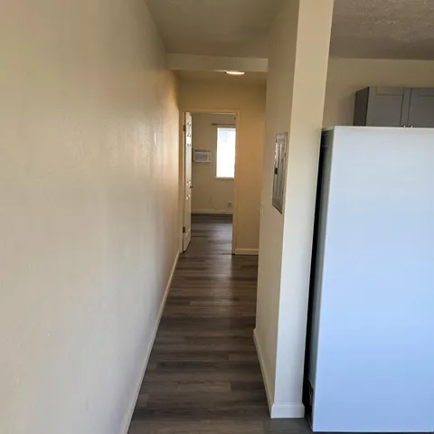 a view of a hallway with wooden floor and staircase