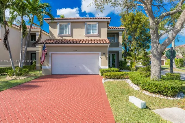 a front view of a house with a garden and yard