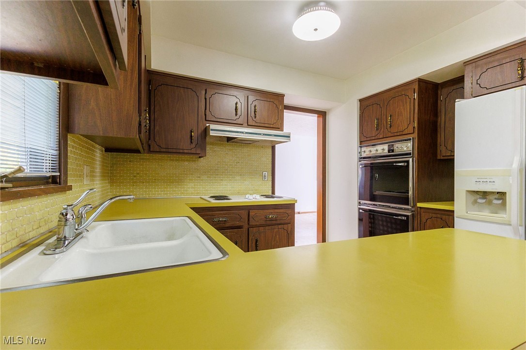 966 Brainard Road Cleveland, OH 44143 - Photo 23 of 50 Kitchen featuring sink, white appliances, and tasteful backsplash