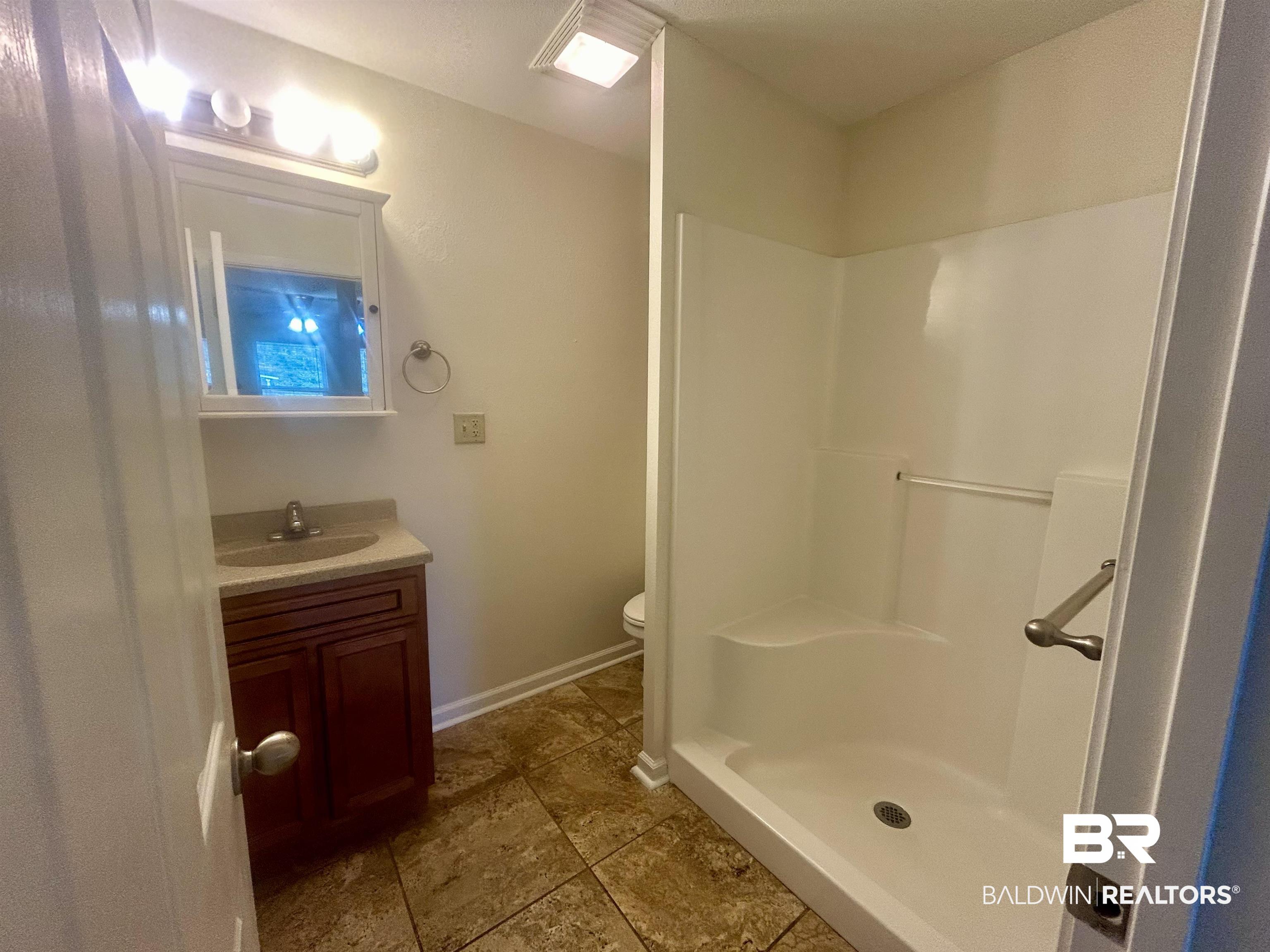 187 Van Hoosen Road Flomaton, AL 36441 - Photo 13 of 29 Bathroom featuring vanity, a stall shower, and dark tile patterned floors