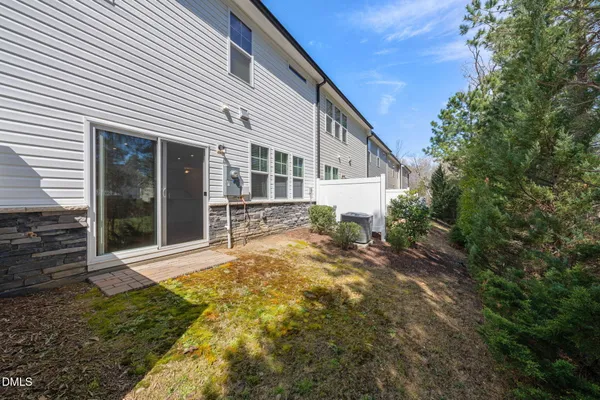 a view of a house with large trees and plants