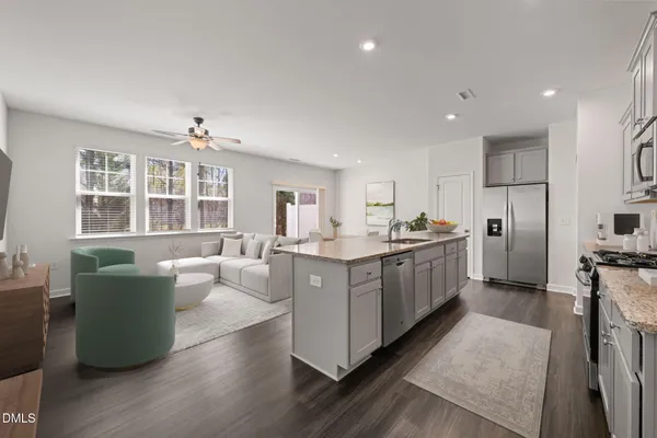 a kitchen with stainless steel appliances kitchen island wooden floors and white cabinets