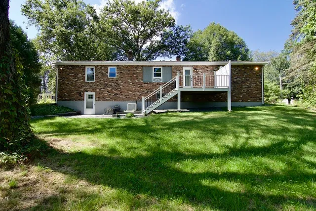 a front view of a house with a yard and trees
