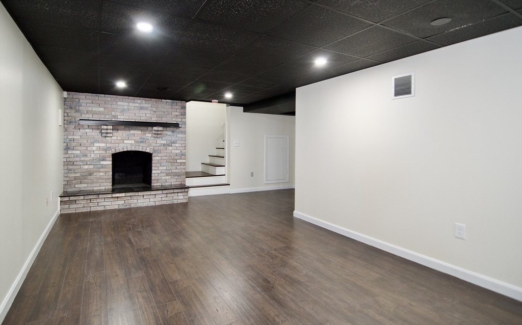 12 Dwight Street Hatfield, MA 01038 - Photo 32 of 42 an empty room with wooden floor and fireplace