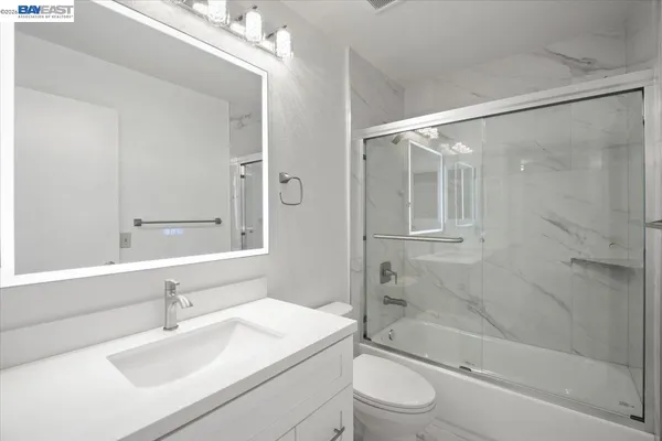 a bathroom with a sink mirror toilet and bathtub