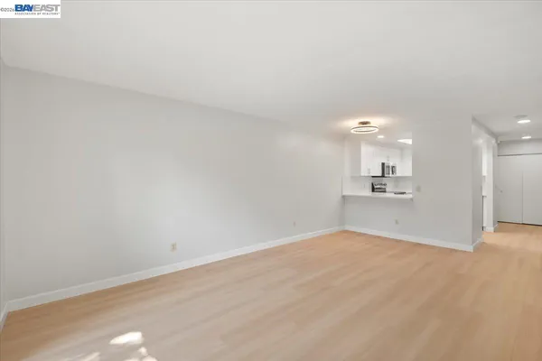 a view of empty room with wooden floor