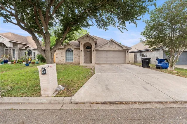 a front view of a house with a yard and trees