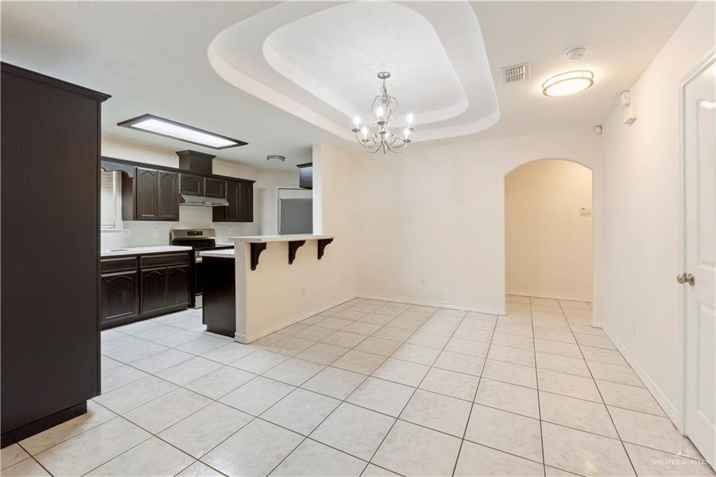4405 North 27th Street McAllen, TX 78504 - Photo 12 of 20 Kitchen with electric stove, arched walkways, a kitchen breakfast bar, light countertops, and a peninsula