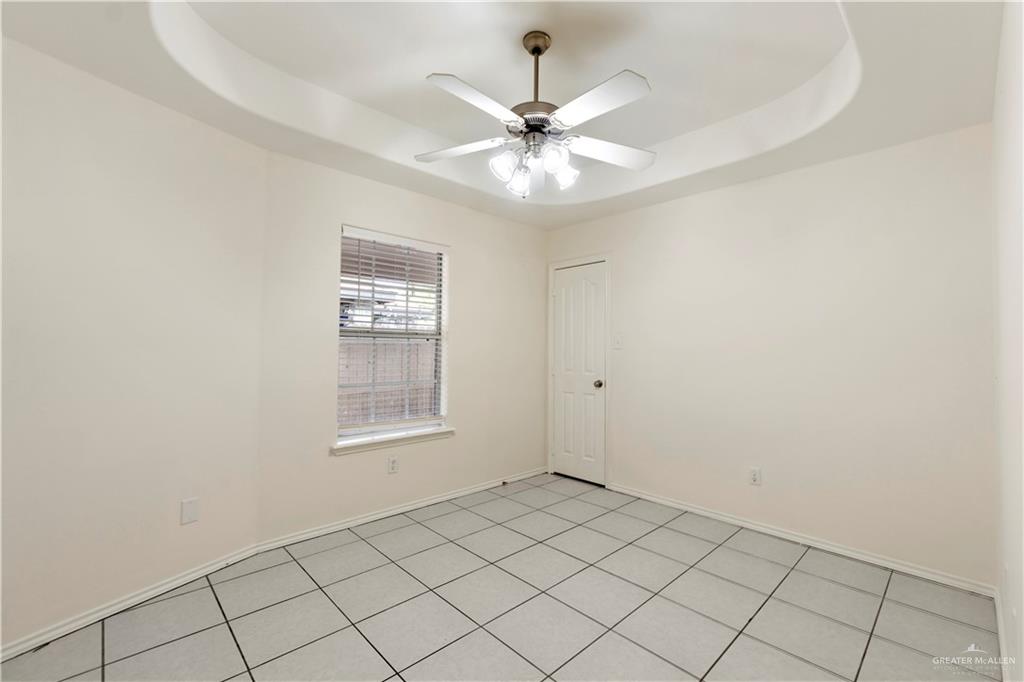 4405 North 27th Street McAllen, TX 78504 - Photo 13 of 20 Unfurnished room featuring a tray ceiling, a ceiling fan, and baseboards