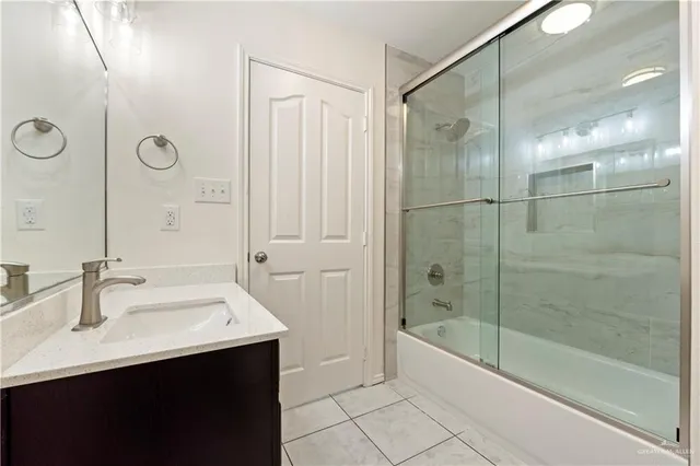 a bathroom with a bath tub sink mirror and shower
