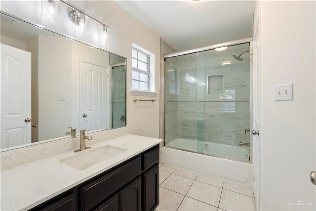 4405 North 27th Street McAllen, TX 78504 - Photo 17 of 20 Bathroom with tile patterned flooring, vanity, and shower / bath combination with glass door