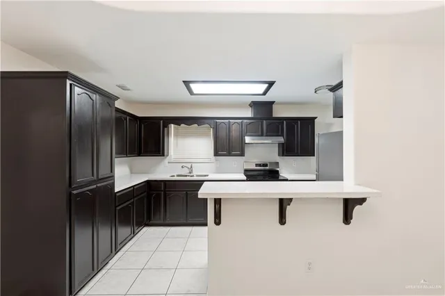 a kitchen with a sink stainless steel appliances and cabinets