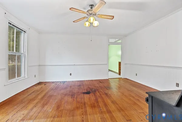 a view of empty room with wooden floor