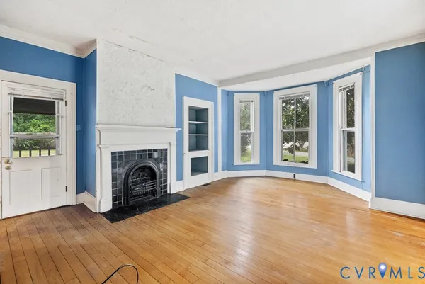 a view of empty room with wooden floor and fireplace