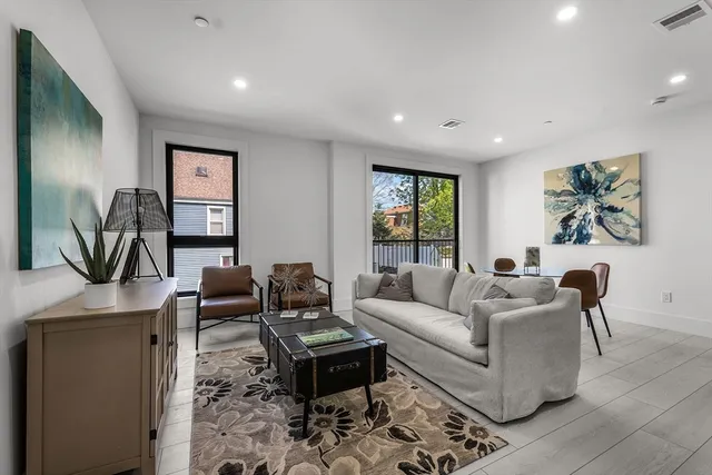 a living room with furniture a desk and chair with the wooden floor