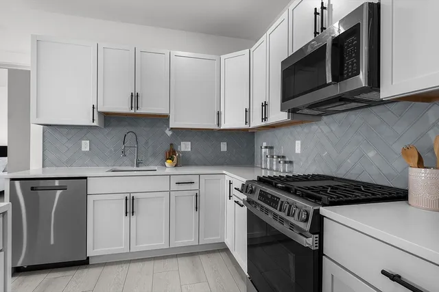 a kitchen with cabinets stainless steel appliances and a sink
