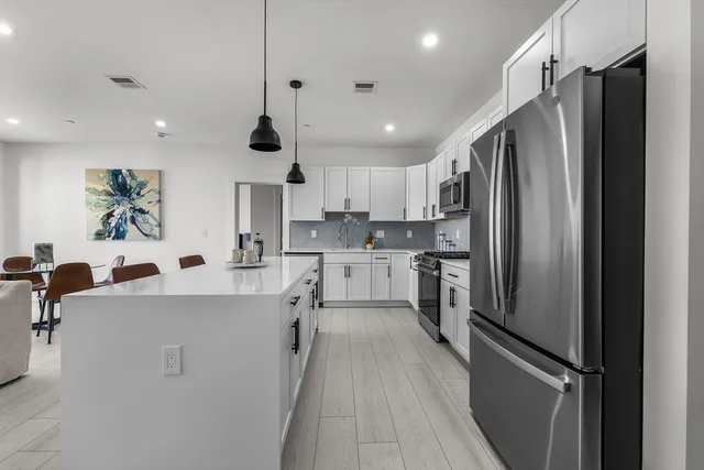a kitchen with stainless steel appliances a refrigerator sink and stove