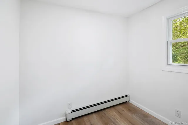 a room with a wooden floor and a window