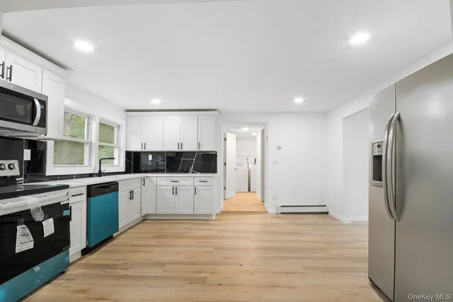 a large kitchen with cabinets and stainless steel appliances