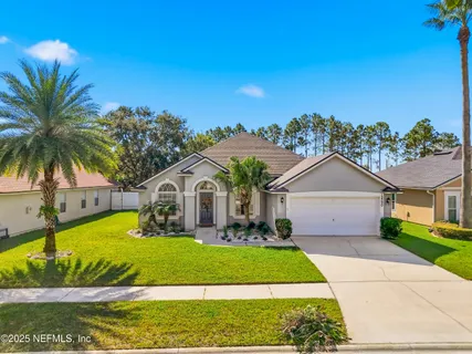 a front view of a house with a garden and plants