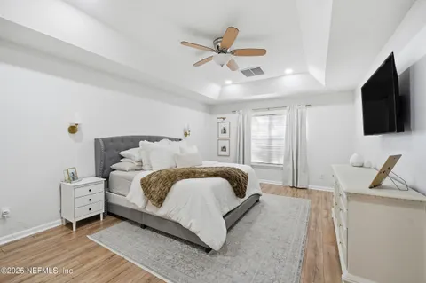 a spacious bedroom with a bed and a flat screen tv