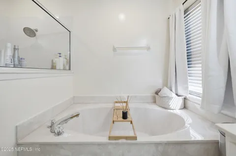 a bathroom with a tub sink and a mirror