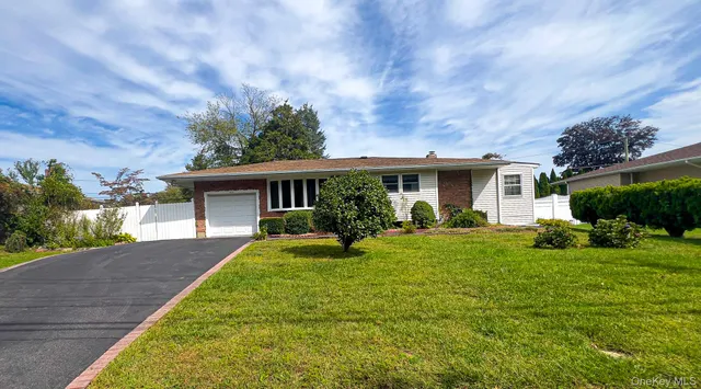 a view of house with a big yard and potted plants