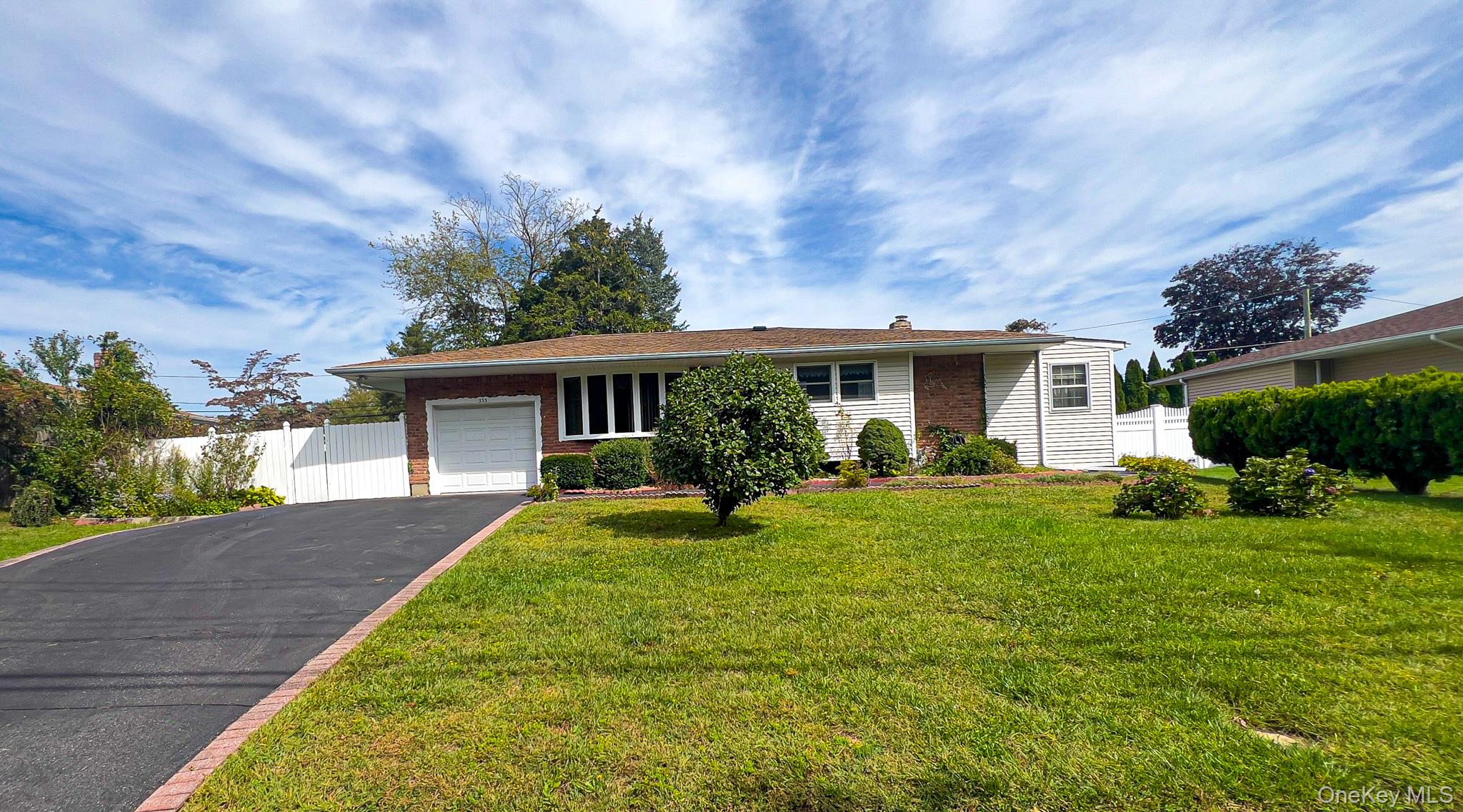 a view of house with a big yard and potted plants