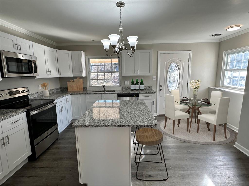3095 Tuscarawas Road Beaver, PA 15009 - Photo 8 of 25 a kitchen with stainless steel appliances granite countertop a stove top oven a sink dishwasher a dining table and chairs with wooden floor
